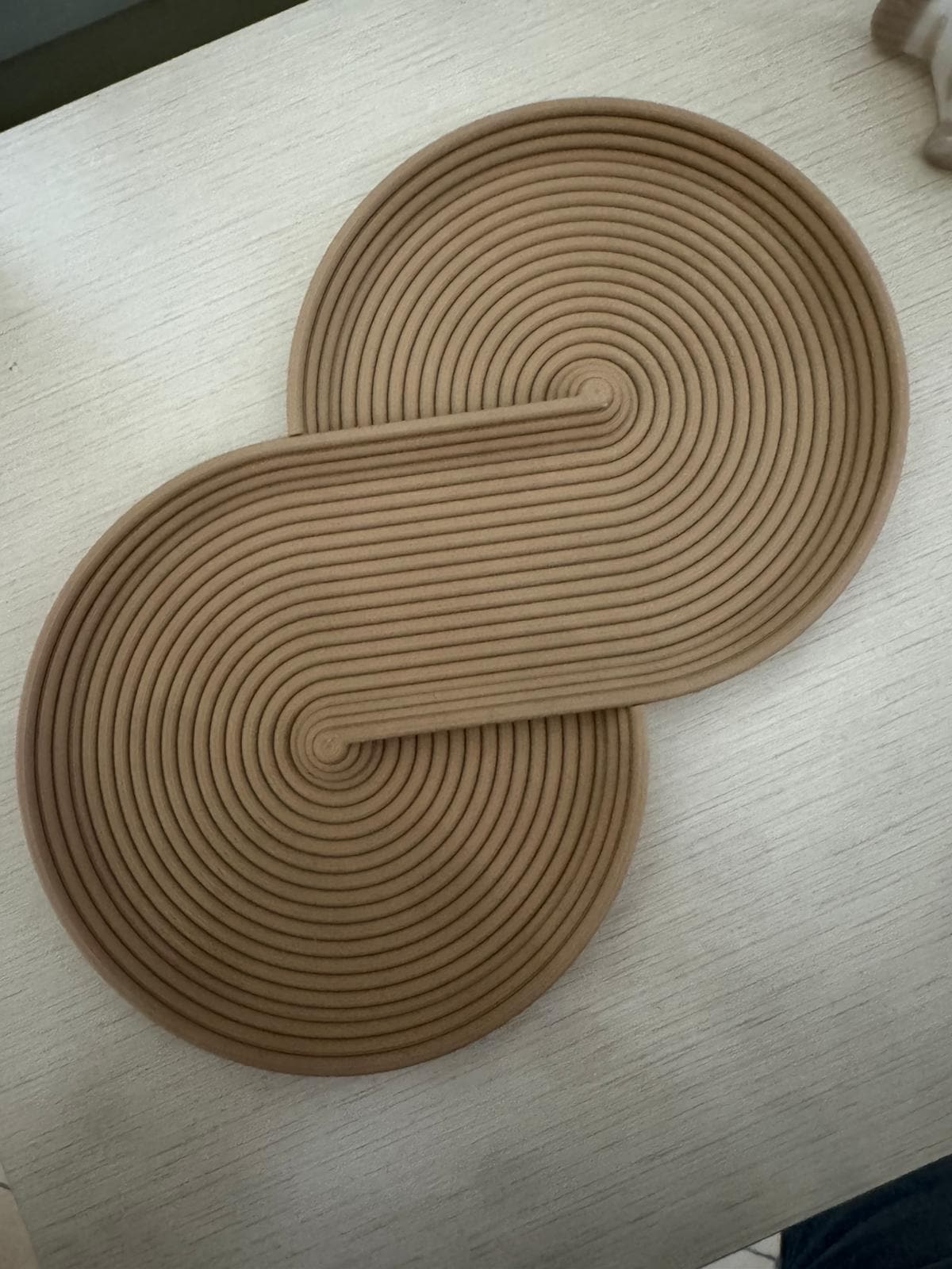 Svuotatasche Infinity beige visto dall'alto, dettaglio delle linee continue in rilievo