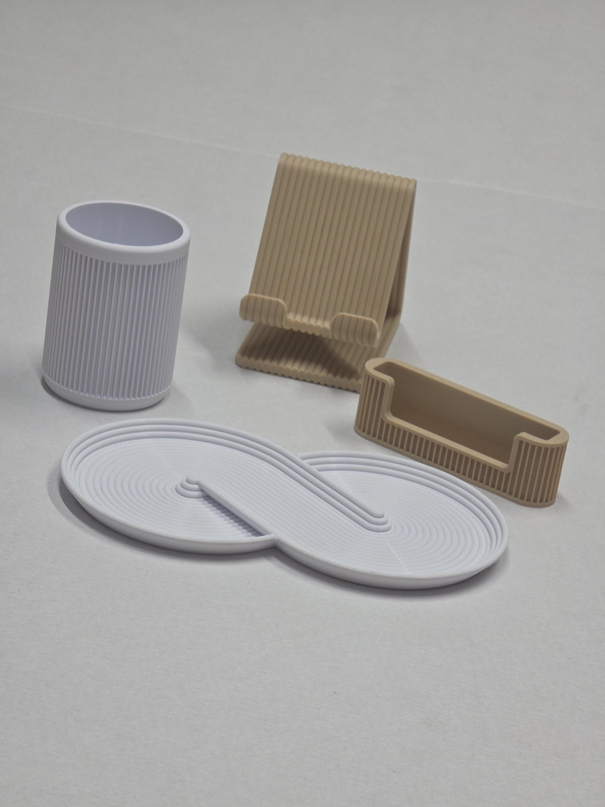 Set da scrivania con portapenne e svuotatasche chiari, supporto telefono e portabiglietti beige