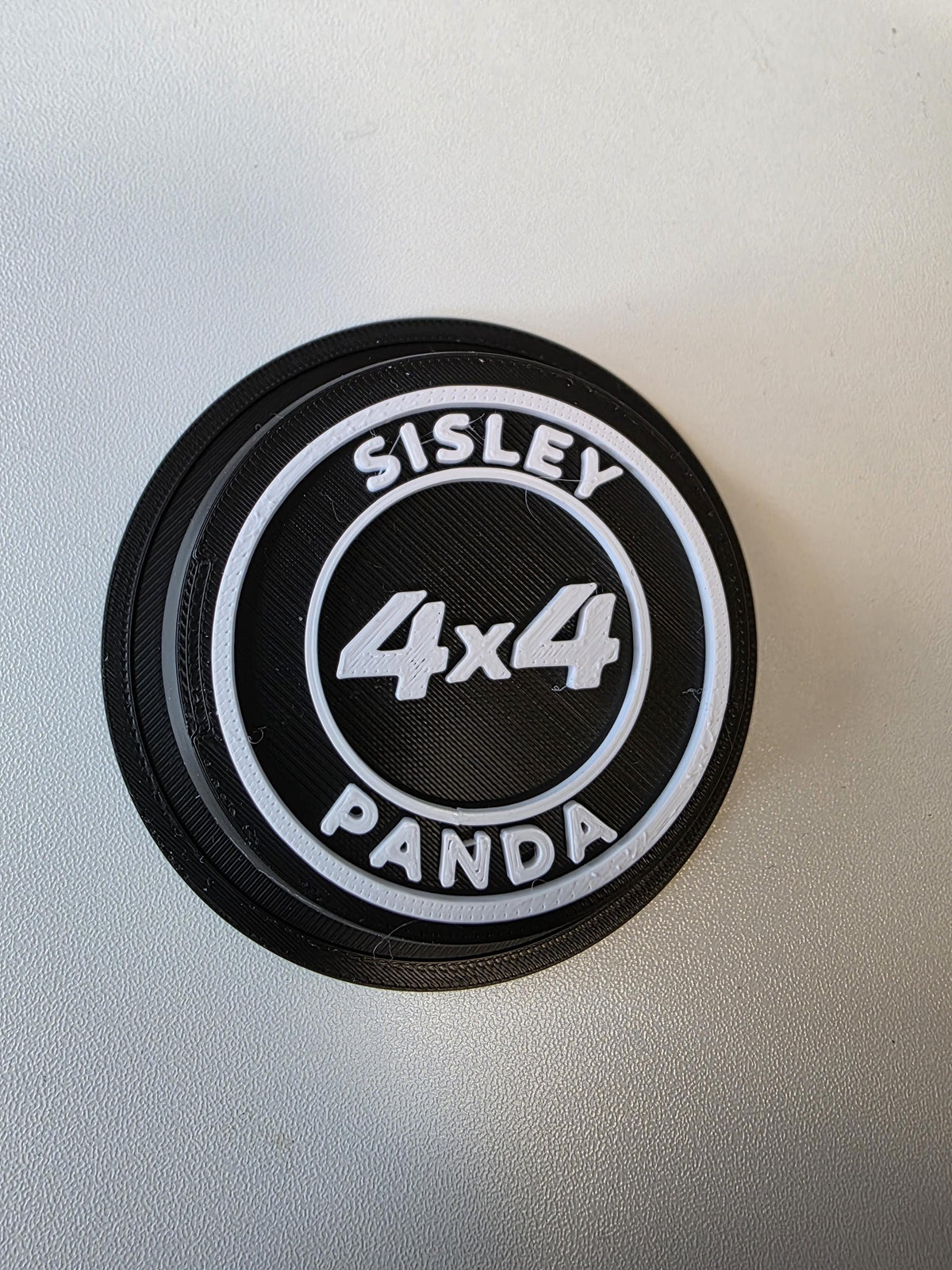 Vista frontale del coprimozzo Panda 4x4 Sisley con anelli e scritte bianche