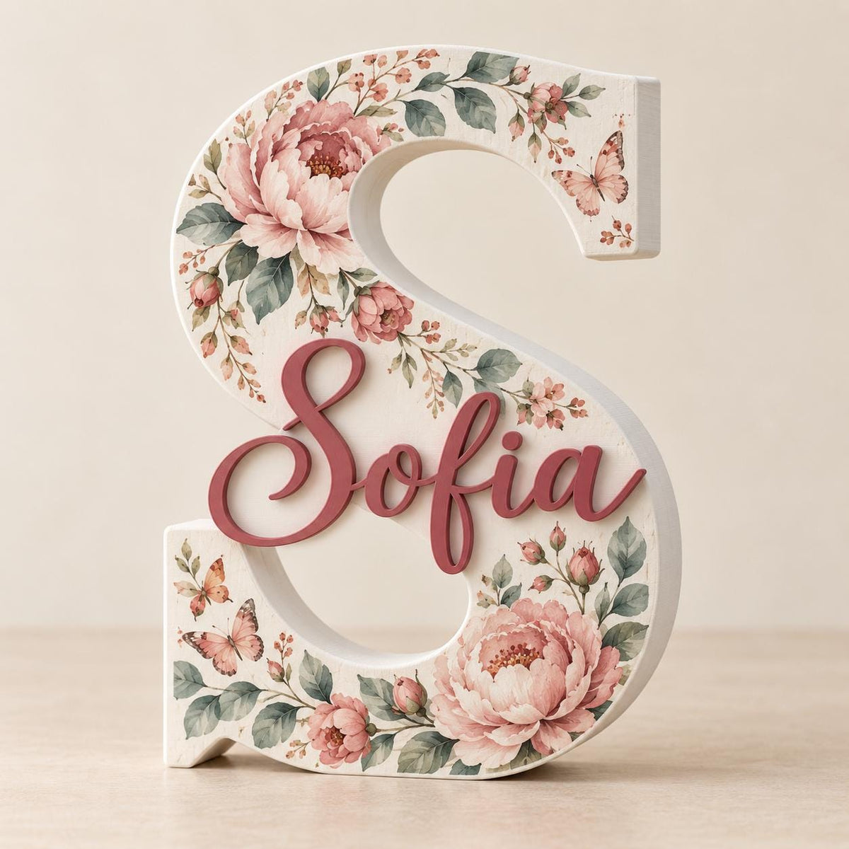 Lettera S personalizzata con fiori rosa, foglie, farfalle e nome Sofia in rilievo.