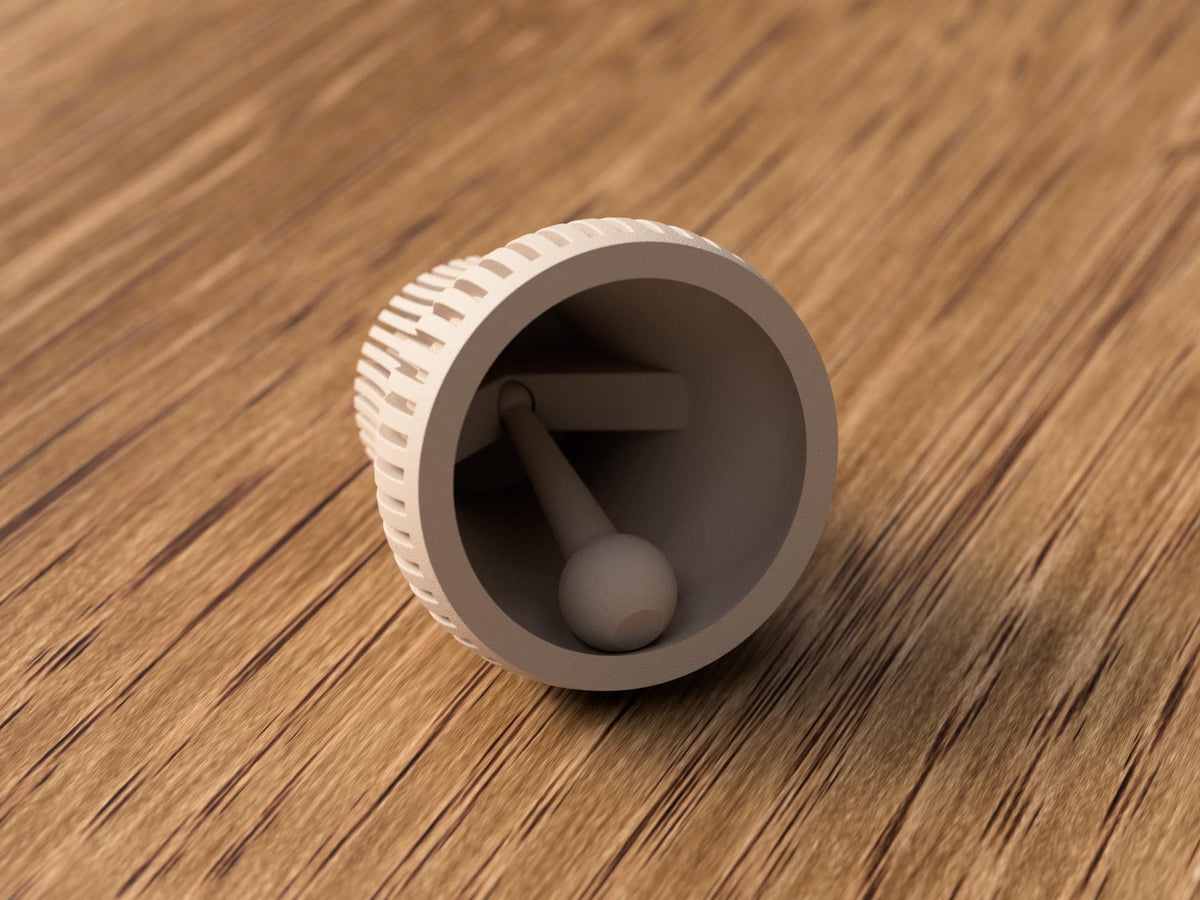 Interno della campana natalizia beige con batacchio già montato, su un piano in legno.