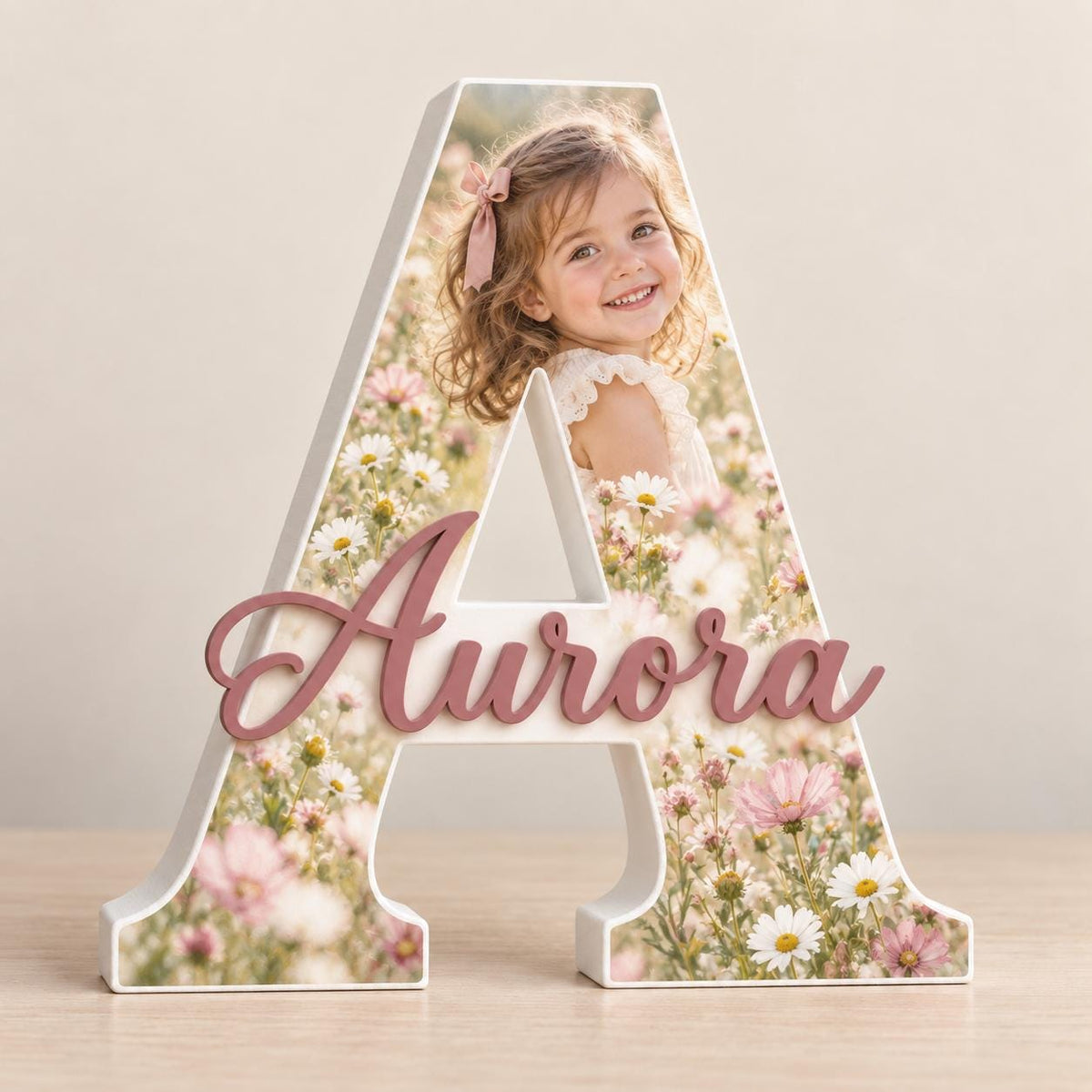 Anteprima di lettera A con fotografia di una bambina tra i fiori e nome Aurora in rilievo.