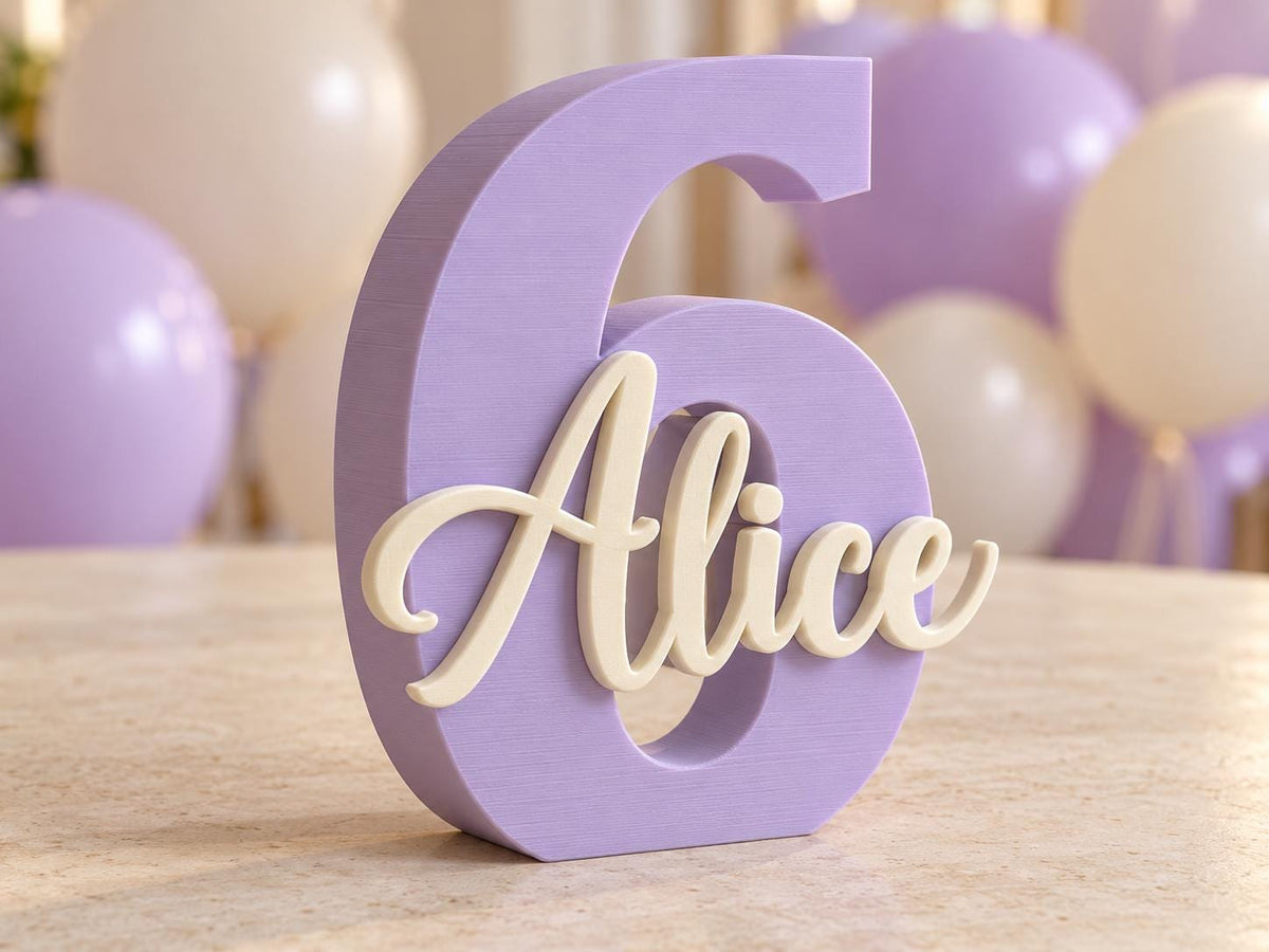 Numero 6 lilla con nome Alice avorio in rilievo, su tavolo con palloncini sullo sfondo.