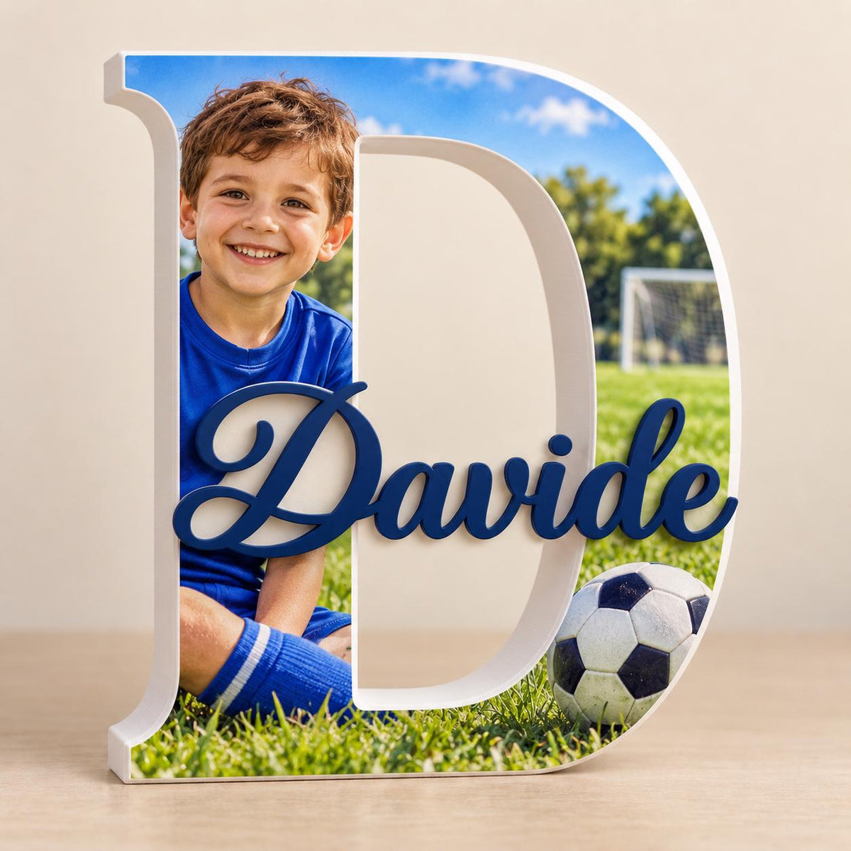 Anteprima di lettera D con foto di un bambino in un campo da calcio e nome Davide blu.