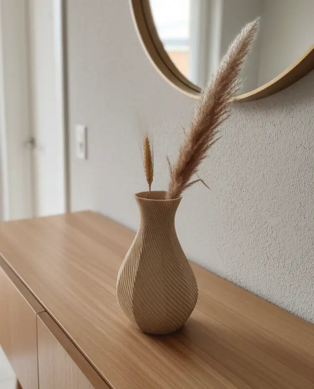 Vaso ottagonale beige con pampas e rami secchi su una consolle in legno sotto uno specchio